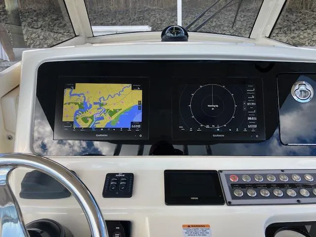 Slide: The Image of 2021 Scout 277 LXF boat dashboard with Garmin navigation displays and controls. - 11