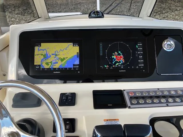 Slide: The Image of 2021 Scout 277 LXF boat dashboard with Garmin navigation displays. - 13