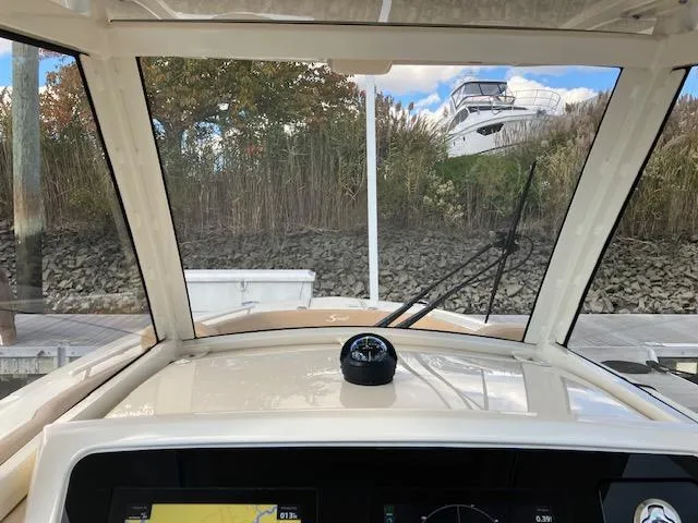 Slide: The Image of View from 2021 Scout 277 LXF boat cockpit, showing navigation instruments and outdoor scenery. - 14