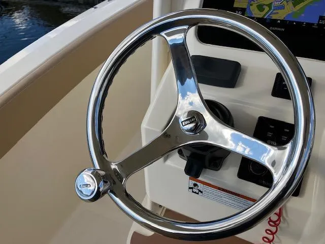 Slide: The Image of 2021 Scout 277 LXF boat steering wheel with control panel and navigation display. - 16