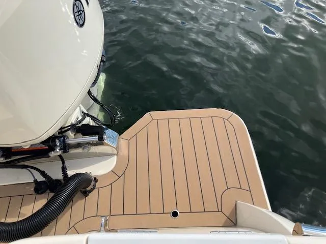 Slide: The Image of 2021 Scout 277 LXF boat deck with outboard motor on water. - 19