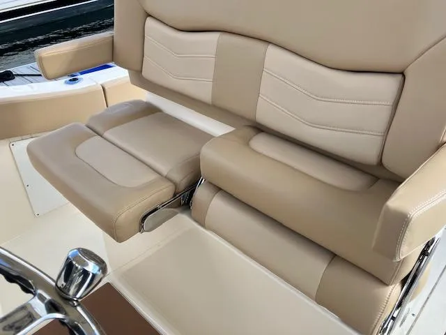 Slide: The Image of 2021 Scout 277 LXF boat seat with beige upholstery and adjustable armrest. - 21
