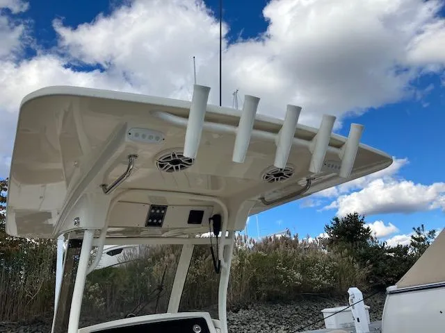 Slide: The Image of 2021 Scout 277 LXF boat with rod holders and speakers under a clear sky. - 23