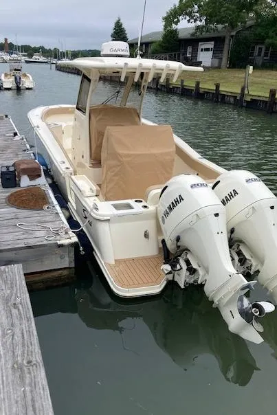 Slide: The Image of 2021 Scout 277 LXF boat with twin Yamaha engines docked in a marina. - 26