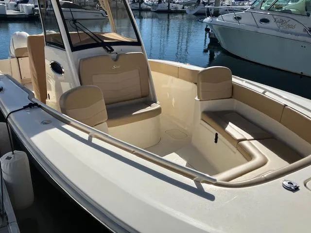 Slide: The Image of 2021 Scout 277 LXF boat with beige seating, docked in a marina. - 3