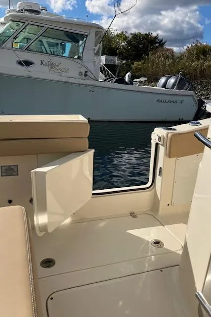 Slide: The Image of 2021 Scout 277 LXF boat interior with open door, docked near another vessel. - 36