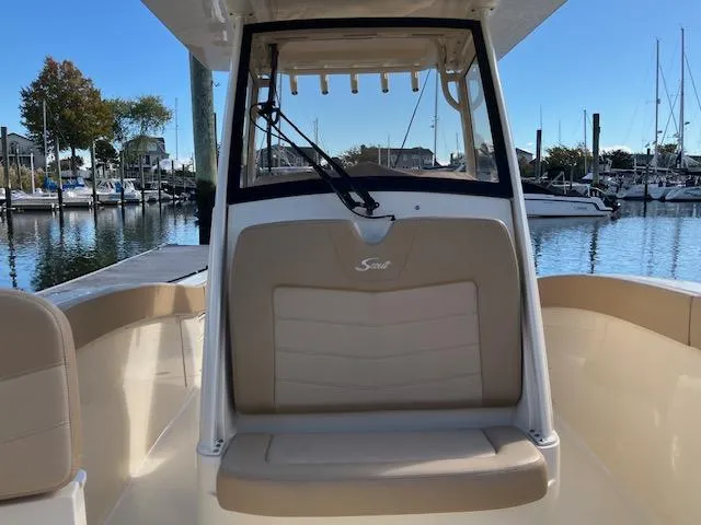 Slide: The Image of 2021 Scout 277 LXF boat interior with beige seating at marina. - 6