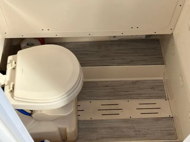 Slide: The Image of 2021 Scout 277 LXF boat bathroom with toilet and wood-style flooring. - 7