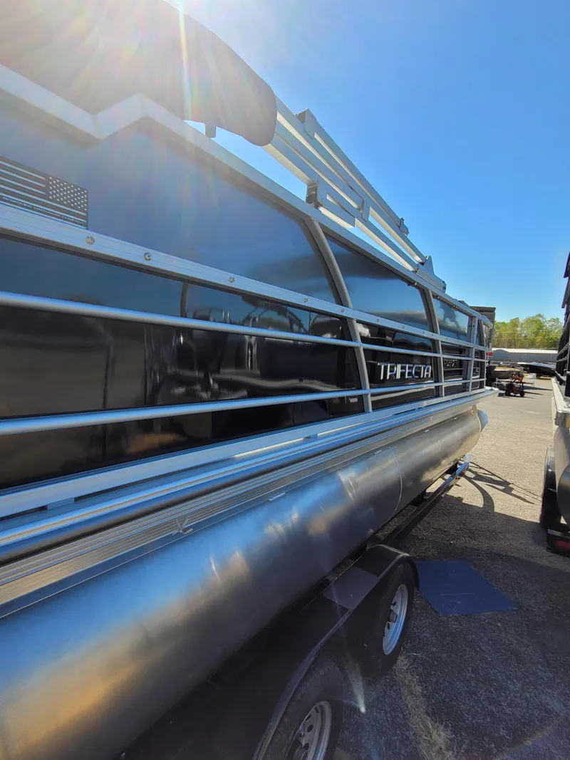 Slide: The Image of 2025 Trifecta 22TRFCLE275 pontoon boat, sleek design, parked outdoors. - 3