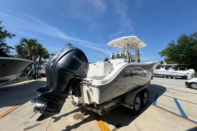 Slide: The Image of 2024 NauticStar 292 Legacy boat with Yamaha engine on trailer, sunny day. - 13