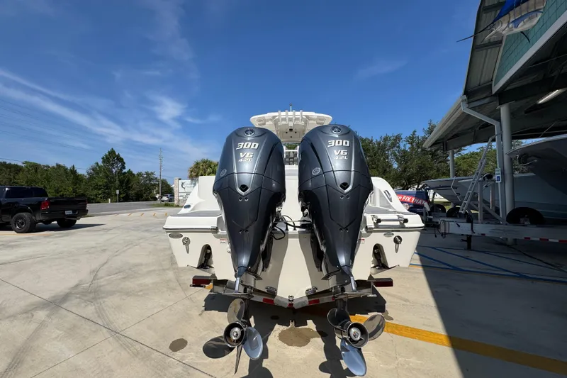 Slide: The Image of 2024 NauticStar 292 Legacy boat with dual 300 V6 outboard engines, parked outdoors. - 15