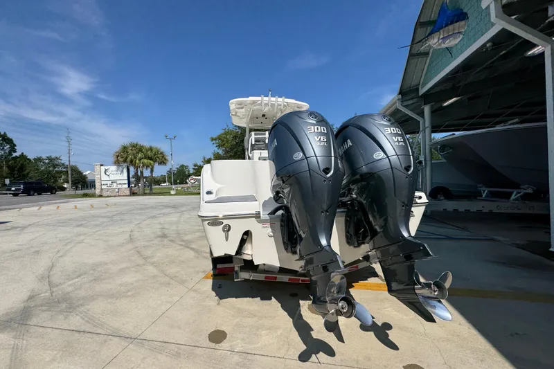 Slide: The Image of 2024 NauticStar 292 Legacy boat with dual Yamaha 300 V6 engines, parked outdoors. - 16