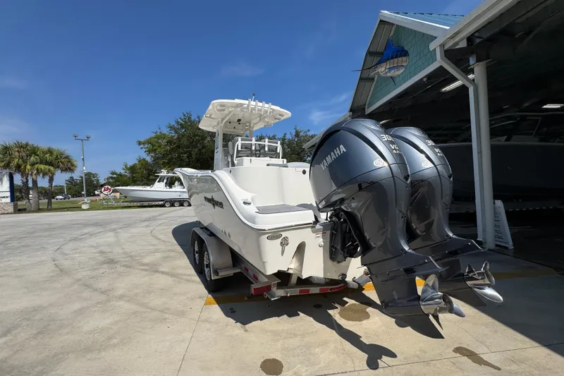 Slide: The Image of 2024 NauticStar 292 Legacy boat with dual Yamaha engines on a trailer. - 17