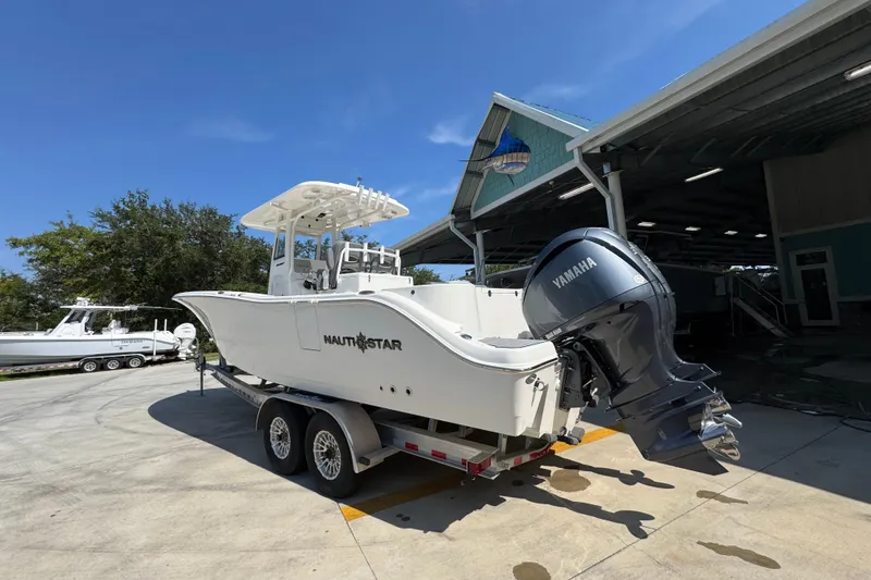 Slide: The Image of 2024 NauticStar 292 Legacy boat on trailer with Yamaha engine, parked outdoors. - 18