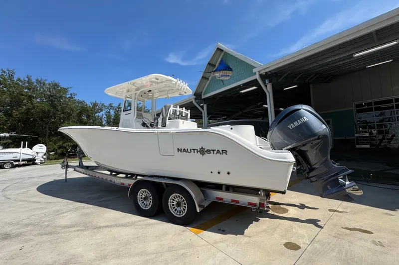 Slide: The Image of 2024 NauticStar 292 Legacy boat on trailer with Yamaha engine, parked outdoors. - 19