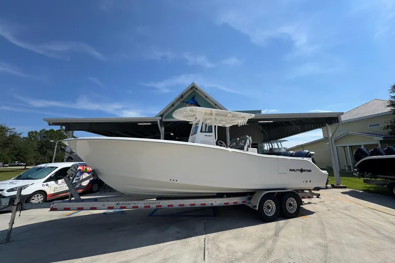 Slide: The Image of 2024 NauticStar 292 Legacy boat on trailer under clear blue sky. - 2