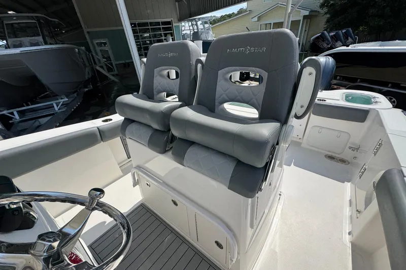 Slide: The Image of 2024 NauticStar 292 Legacy boat with dual cushioned seats and steering wheel. - 26