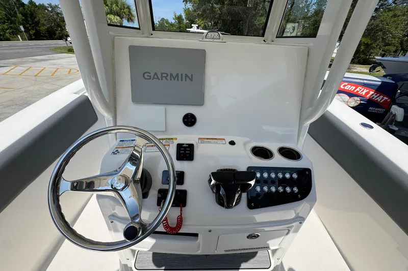 Slide: The Image of 2024 NauticStar 292 Legacy boat helm with Garmin display and steering wheel. - 30