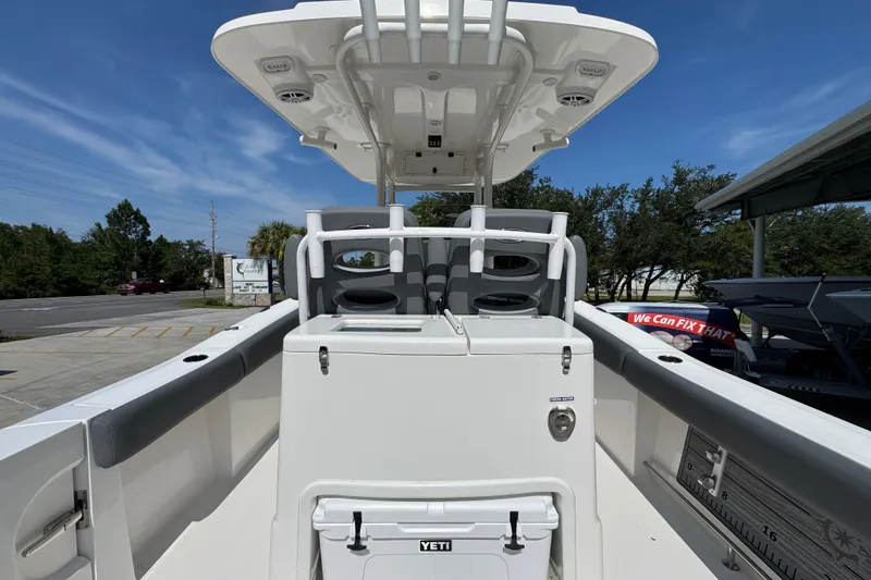 Slide: The Image of 2024 NauticStar 292 Legacy boat interior with seating and storage under a clear blue sky. - 33