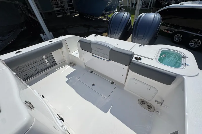 Slide: The Image of 2024 NauticStar 292 Legacy boat deck with seating, storage, and twin engines. - 36