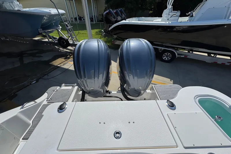 Slide: The Image of 2024 NauticStar 292 Legacy boat with dual outboard engines, docked in a marina. - 38