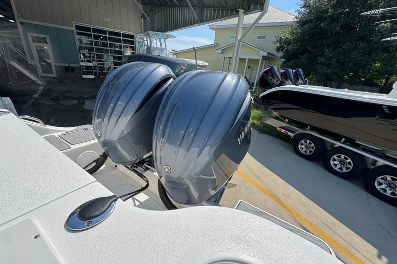 Slide: The Image of 2024 NauticStar 292 Legacy with dual Yamaha outboard engines at a marina. - 39