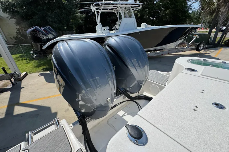 Slide: The Image of 2024 NauticStar 292 Legacy boat with dual outboard engines, parked on a trailer. - 40