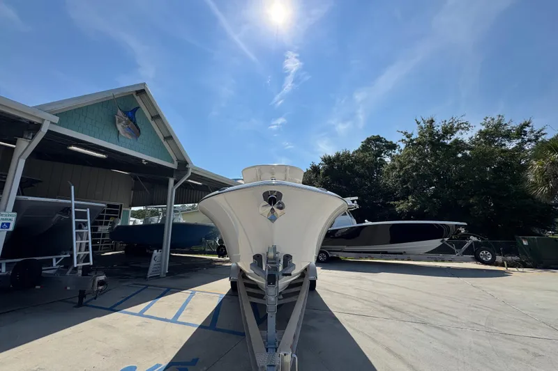 Slide: The Image of 2024 NauticStar 292 Legacy boat on trailer under sunny sky at dealership. - 7