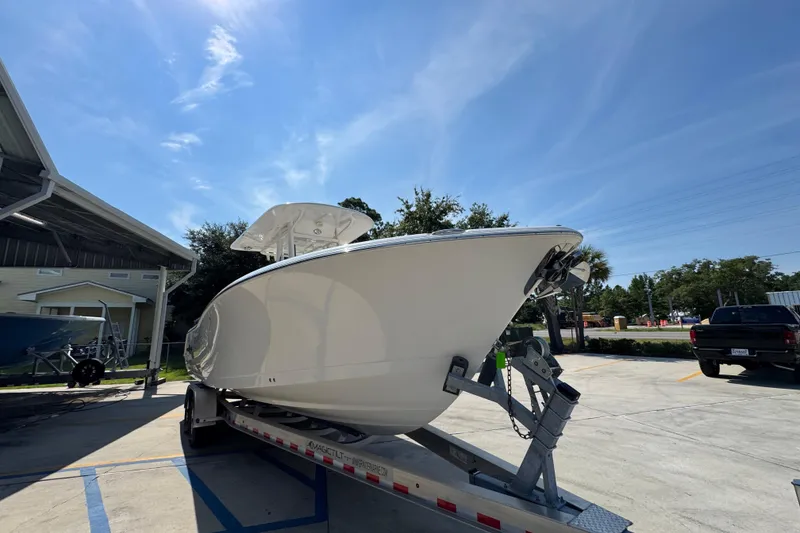 Slide: The Image of 2024 NauticStar 292 Legacy boat on trailer under clear blue sky. - 8