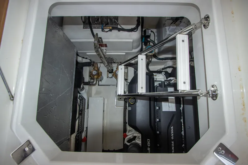 Slide: The Image of Engine compartment of 2024 Riviera 4600 SY yacht with visible machinery and ladder. - 22