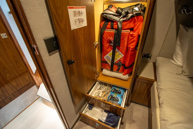 Slide: The Image of 2024 Riviera 4600 SY yacht interior storage with safety equipment and supplies. - 29