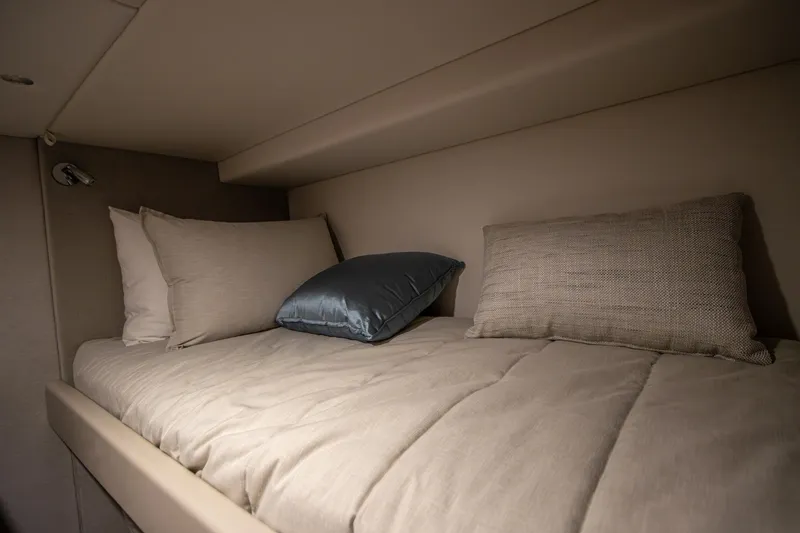Slide: The Image of 2024 Riviera 4600 SY cabin with cozy bedding and pillows. - 30