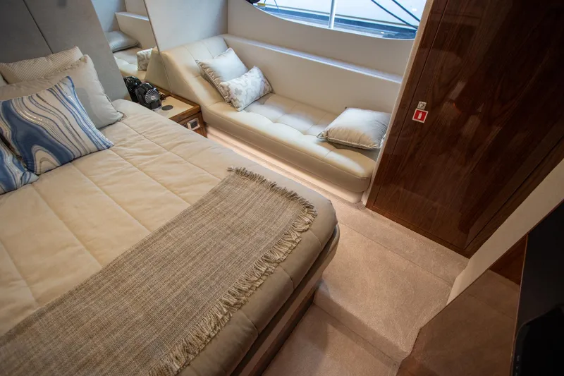 Slide: The Image of Luxurious interior of 2024 Riviera 4600 SY yacht with cozy bed and seating area. - 32