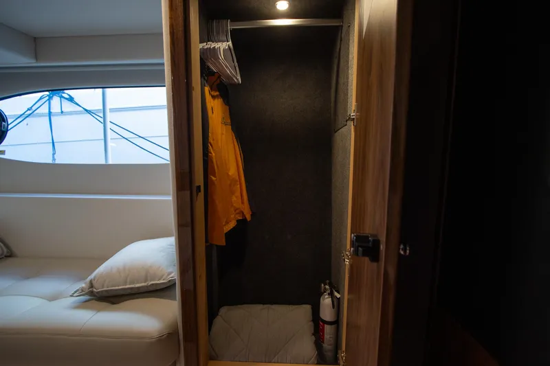 Slide: The Image of Interior of 2024 Riviera 4600 SY yacht with closet and seating area. - 36