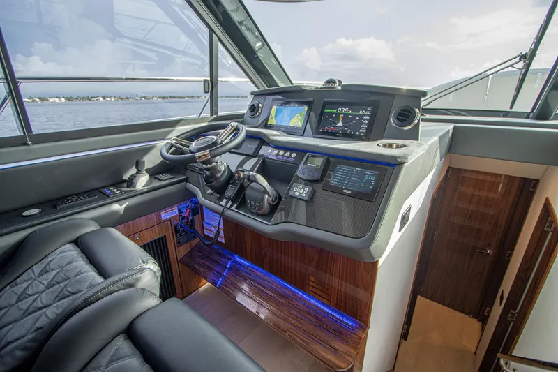 Slide: The Image of 2024 Riviera 4600 SY yacht helm with modern navigation systems and luxurious seating. - 46