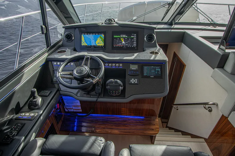 Slide: The Image of 2024 Riviera 4600 SY yacht helm with advanced navigation displays and luxurious interior. - 48