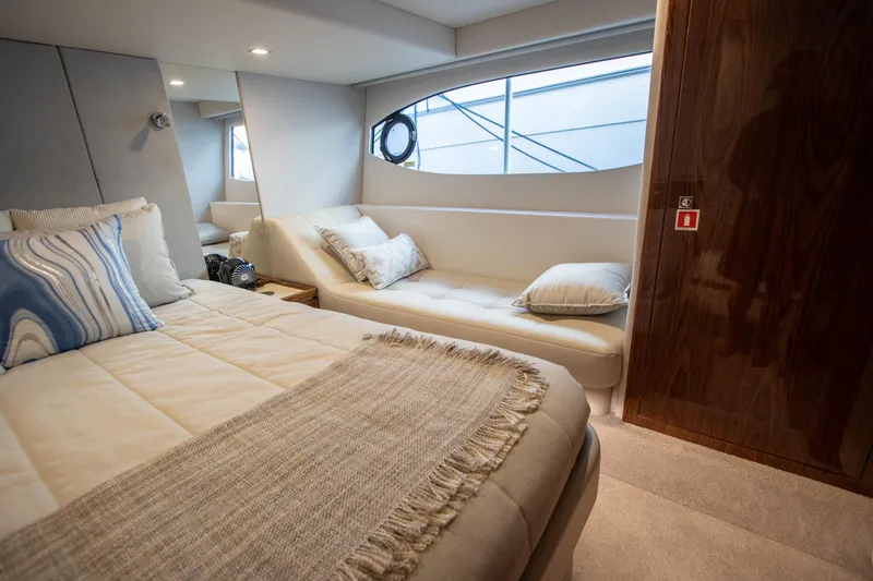 Slide: The Image of Luxurious interior of 2024 Riviera 4600 SY yacht with cozy bed and seating area. - 8