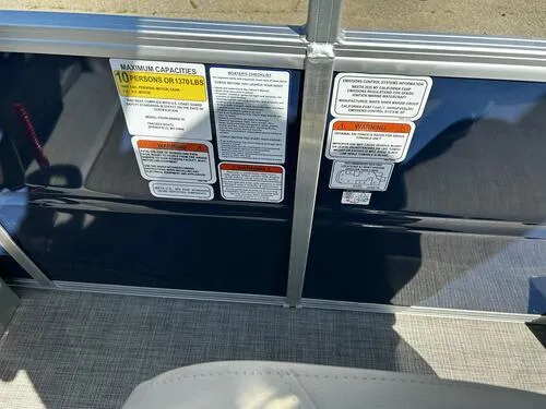 Slide: The Image of 2025 Sun Tracker Fishin' Barge 20 DLX safety and capacity labels on boat interior. - 11