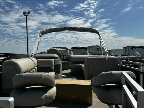 Slide: The Image of 2025 Sun Tracker Fishin' Barge 20 DLX pontoon boat with spacious seating under a clear sky. - 5