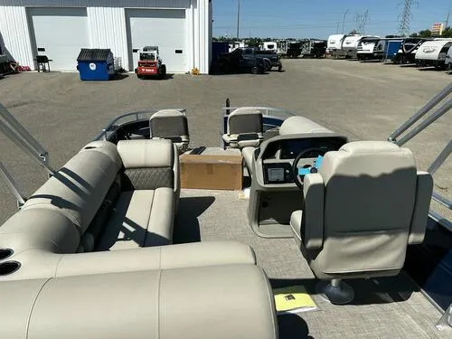 Slide: The Image of 2025 Sun Tracker Fishin' Barge 20 DLX interior with beige seating and steering console. - 9