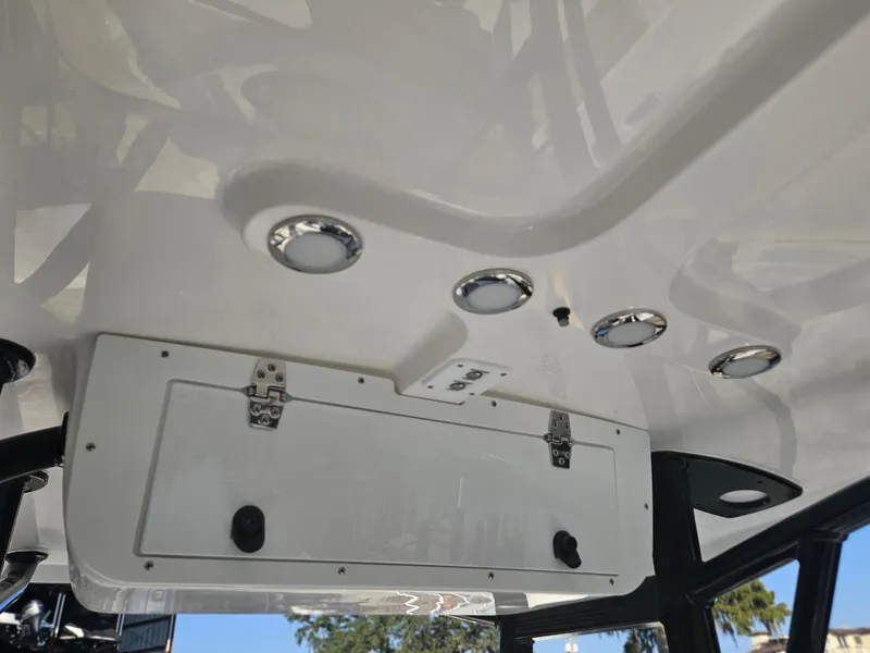 Slide: The Image of 2025 Sea Hunt Ultra 229 boat interior ceiling with storage compartment and lights. - 11
