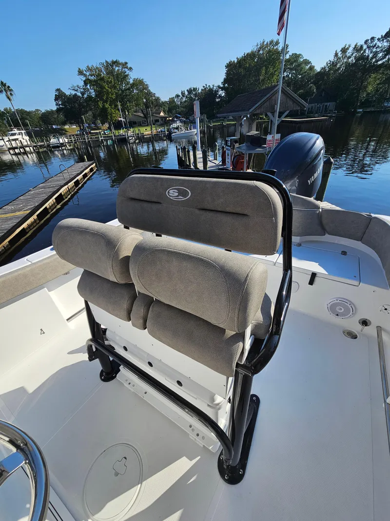 Slide: The Image of 2025 Sea Hunt Ultra 229 boat interior with cushioned seating by a serene waterfront. - 17