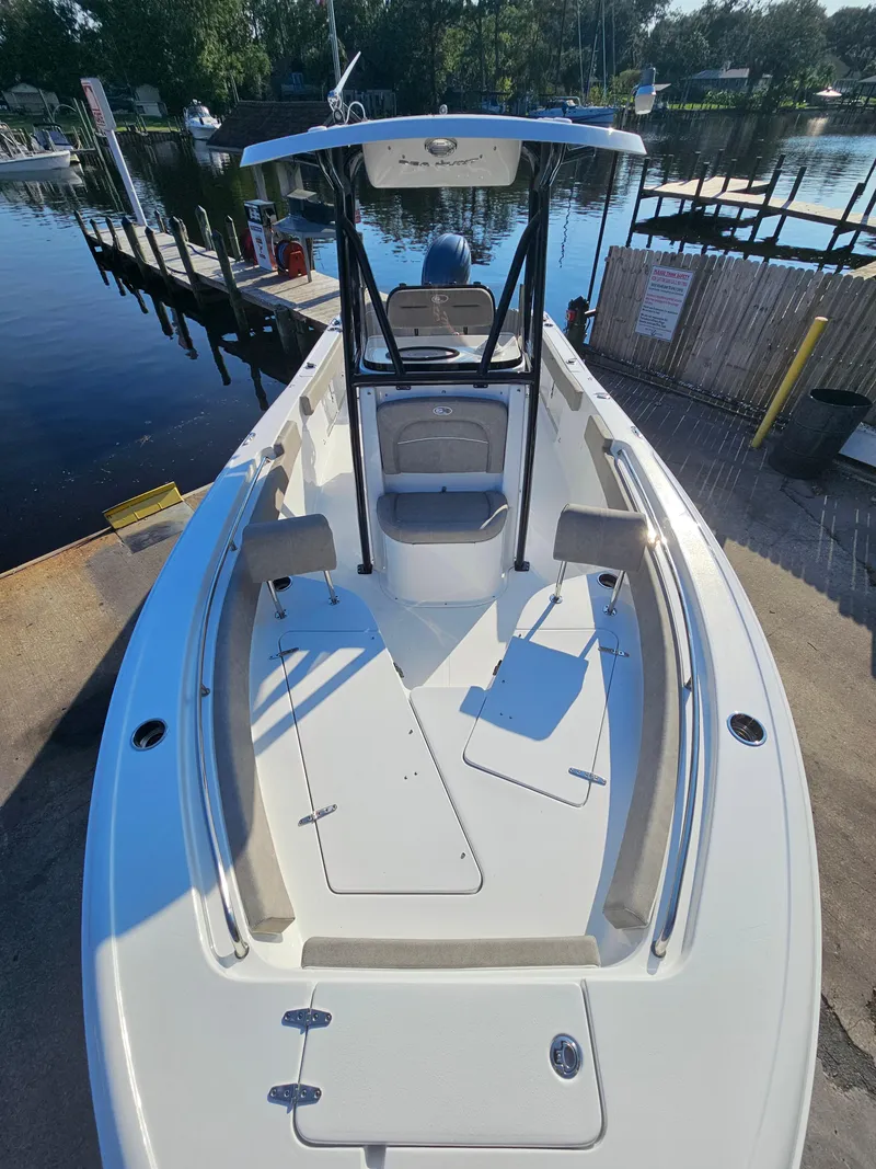 Slide: The Image of 2025 Sea Hunt Ultra 229 boat docked at a marina, showcasing spacious deck and seating. - 20