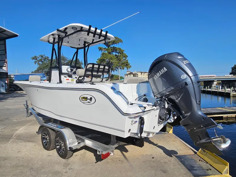Slide: The Image of 2025 Sea Hunt Ultra 229 boat with Yamaha engine on trailer by dock. - 4