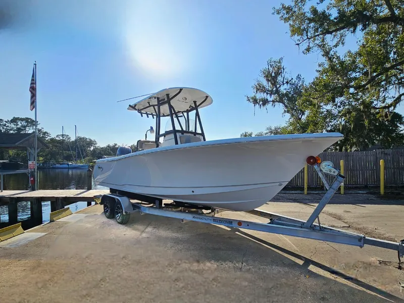 Slide: The Image of 2025 Sea Hunt Ultra 229 boat on trailer at dockside under clear sky. - 9