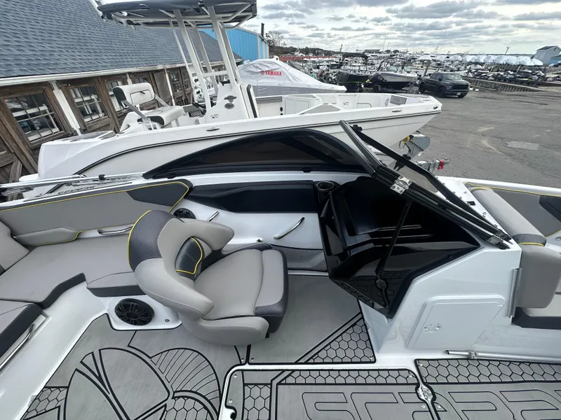 Slide: The Image of 2020 Scarab 195 ID boat interior with modern seating and dashboard, docked at a marina. - 11