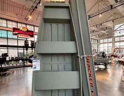 The Image of 2025 Tracker Grizzly 1036 Utility boat displayed in a showroom with Mercury Power signage. - 0