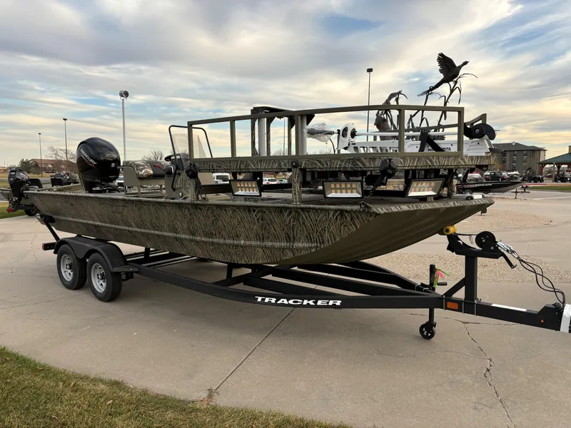 The Image of 2025 Tracker Grizzly 2072 CC Sportsman boat on trailer, parked outdoors. - 0