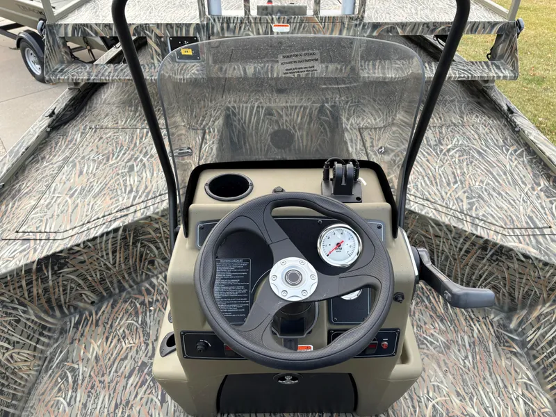 Slide: The Image of 2025 Tracker Grizzly 2072 CC Sportsman boat console with camouflage design and steering wheel. - 7