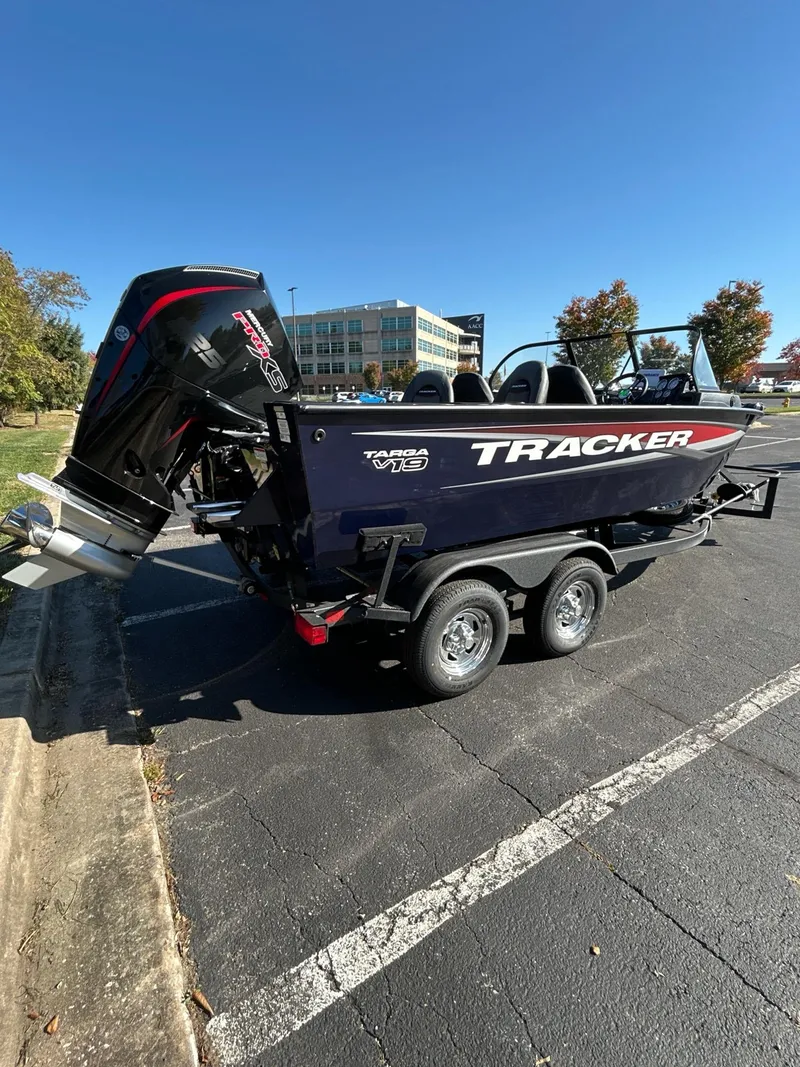 Slide: The Image of 2025 Tracker Targa V-19 WT boat on trailer in parking lot, sunny day. - 2